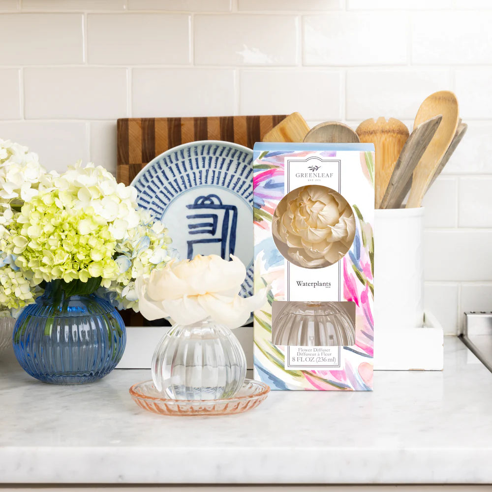 Kitchen counter with decorative items including a vase, flowers, and a waterplants flower diffuser