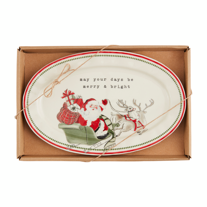 off-white oval ceramic plater with Santa in his sleigh along the bottom and "may your days be merry and bright" printed across the top.