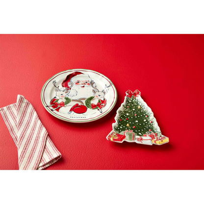 santa platter and tree platter arranged on a red surface with a red striped dishtowel.