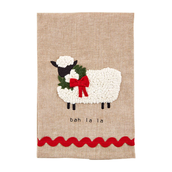 natural colored towel with pom sheep embroidered on it and "bah la la" printed on it.