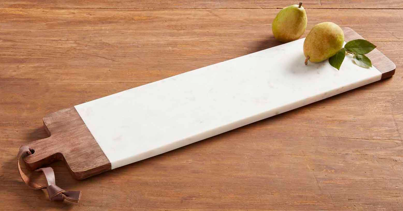 Long Wood and Marble Board on a wooden table with pears on it.