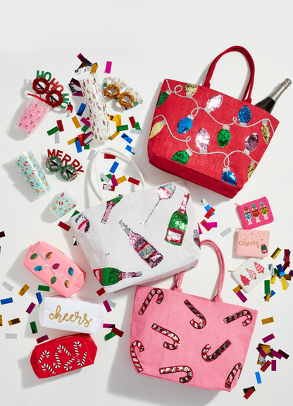 3 styles of holiday sparkle totes arranged on a white surface with confetti and other sparkly bags,