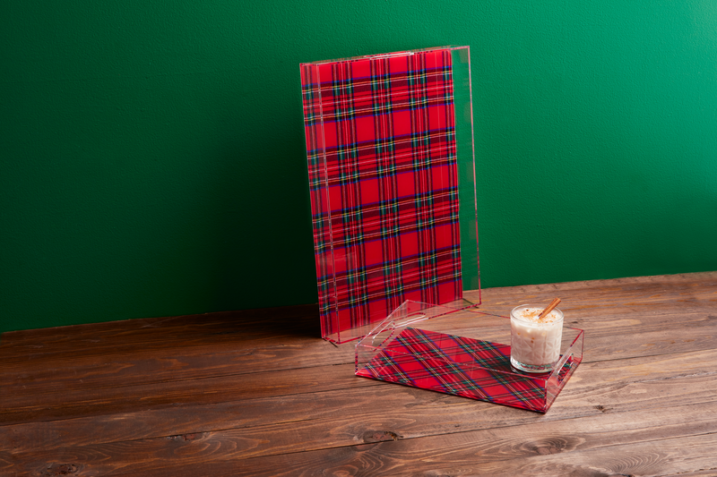 large and small tartan trays arranged on a wooden table, small tray has a drink set on it.