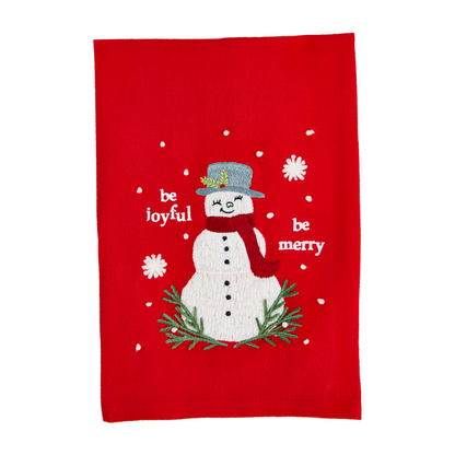 red towel embroidered snowman on it a  "be joyful be merry" printed on it.