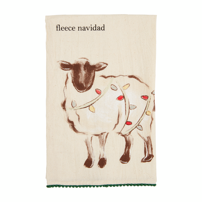 off-white towel with green pom trim with a sheep draped in christmas lights and "fleece nacidad" printed on it.