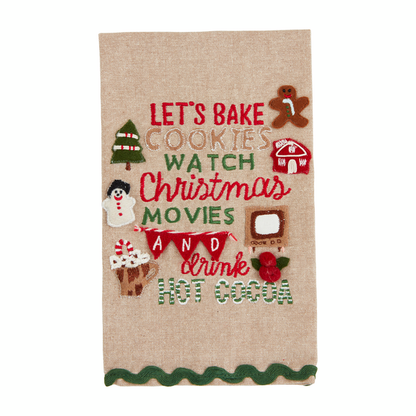 Natural chambray towel with "let's bake cookies watch Christmas movies and drink hot cocoa" stitched on it with applique Christmas icons around it and a green ric-rac trim across the bottom.