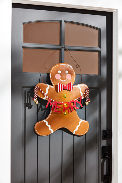 Tin Gingerbread Door Hanger hanging on a black door.