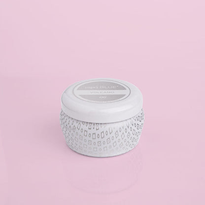 Volcano Signature White Mini Tin Candle on a light pink background.