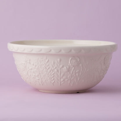 cream colored bowl with embossed floral pattern all around it on a lavender background.