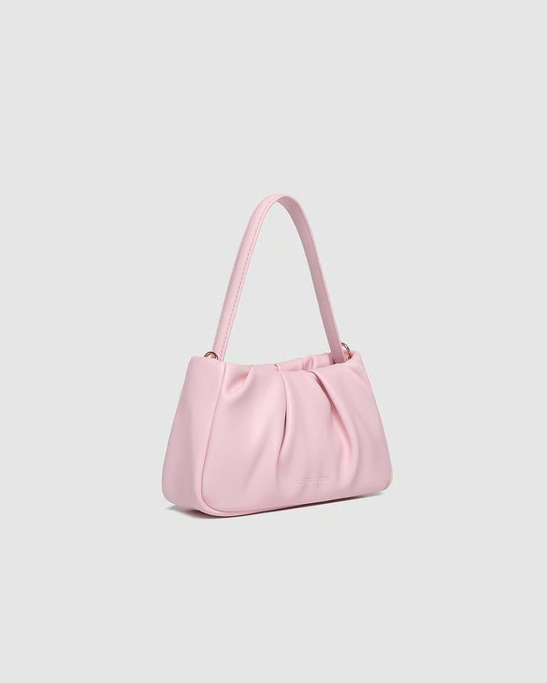 side view of Pink handbag on a light gray background