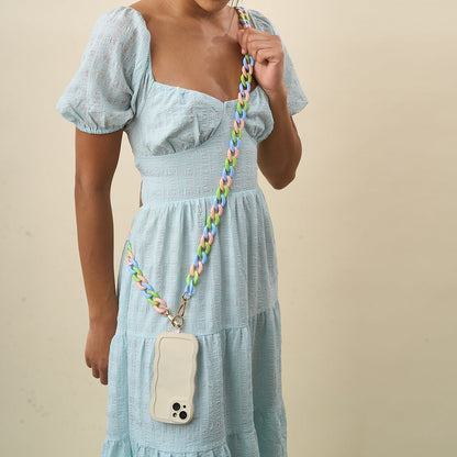person wearing a blue dress and lively phone chain as a crossbody.