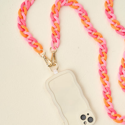 pink and orange phone chain with phone attached arranged on an off-white background.
