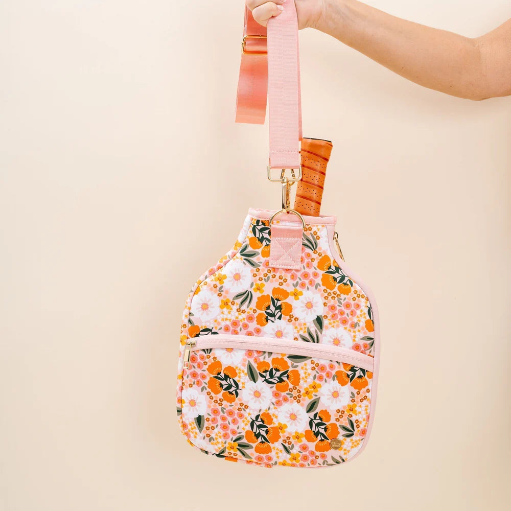 hand holding pink, orange, and white floral pickleball case.