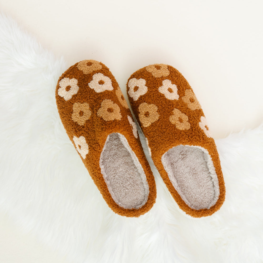 pair of fuzzy floral slippers shown on an off-white background.