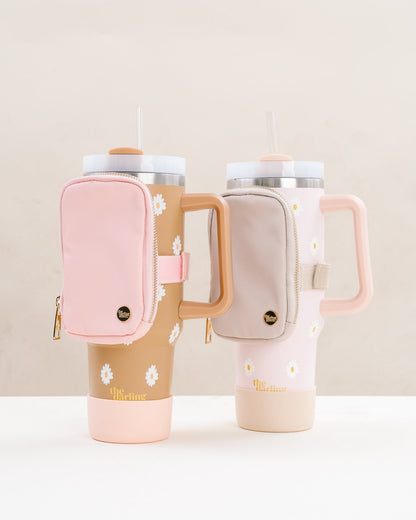 blush and natural tumbler fanny packs on tumblers set on a table..