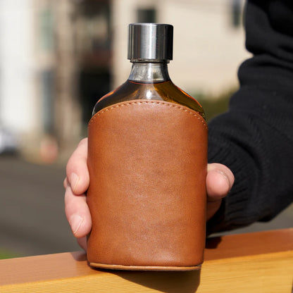 hand holding Leather-Wrapped Glass Flask