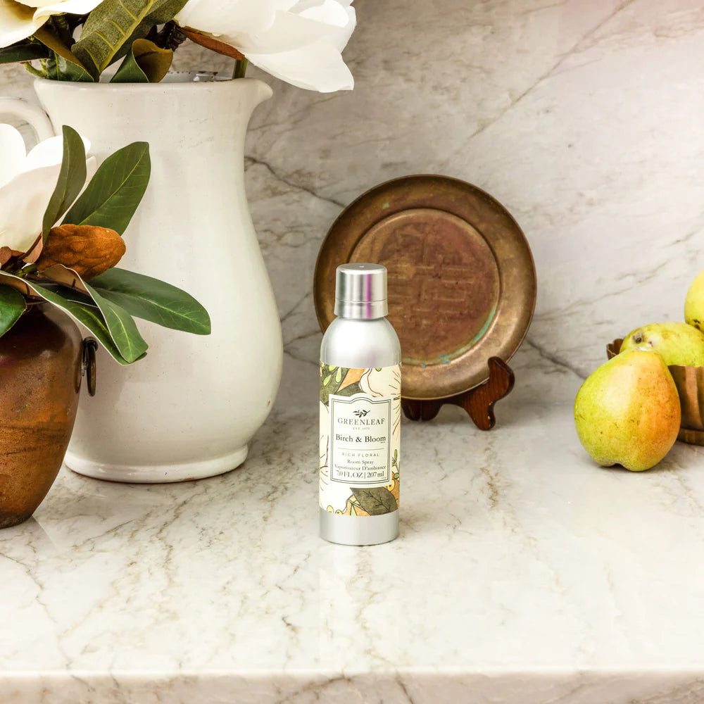 bottle of Birch & Bloom Room Spray set on a counter with decorative items