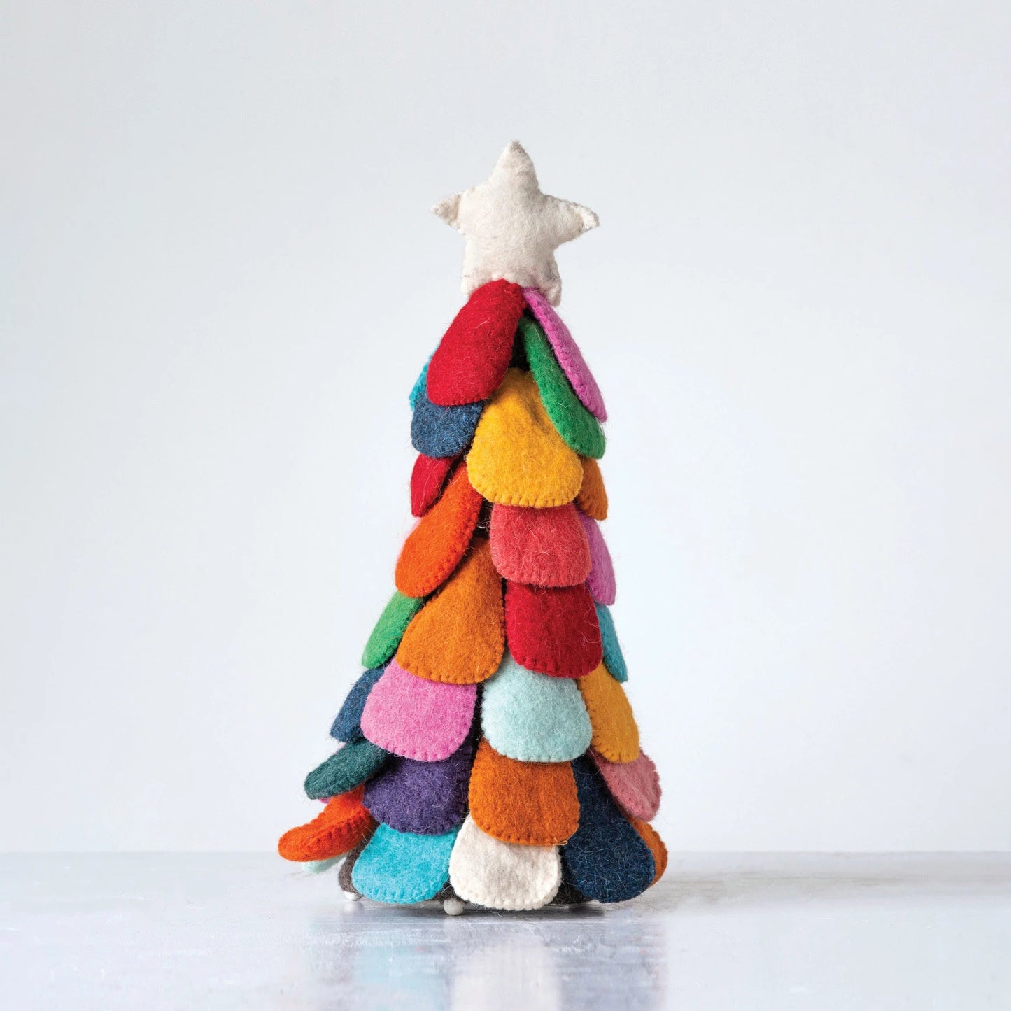 wool felt tree with colorful petals and a white star on top.