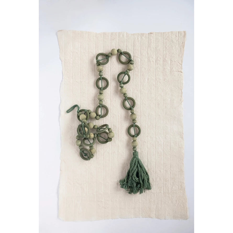 paulownia wood bead garland with tassel displayed on recycled paper