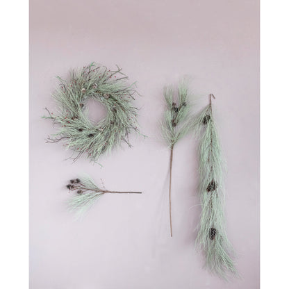 faux long needle pine spray with pinecones displayed next to a pine wreath and pine swag on a light gray surface