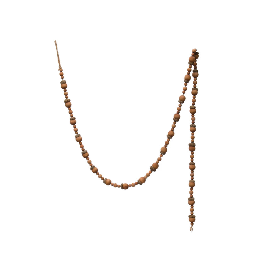 paulownia wood acorn and bead garland displayed on a white background
