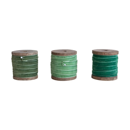 3 shades of green Velvet Ribbon on Wood Spools in a row on a white background