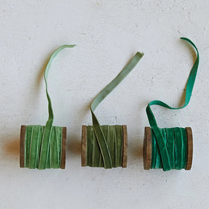 3 SHADES OF GREEN Velvet Ribbon on Wood Spools partially unrolled on a plaster surface