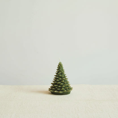 short evergreen tree candle on a decorated surface