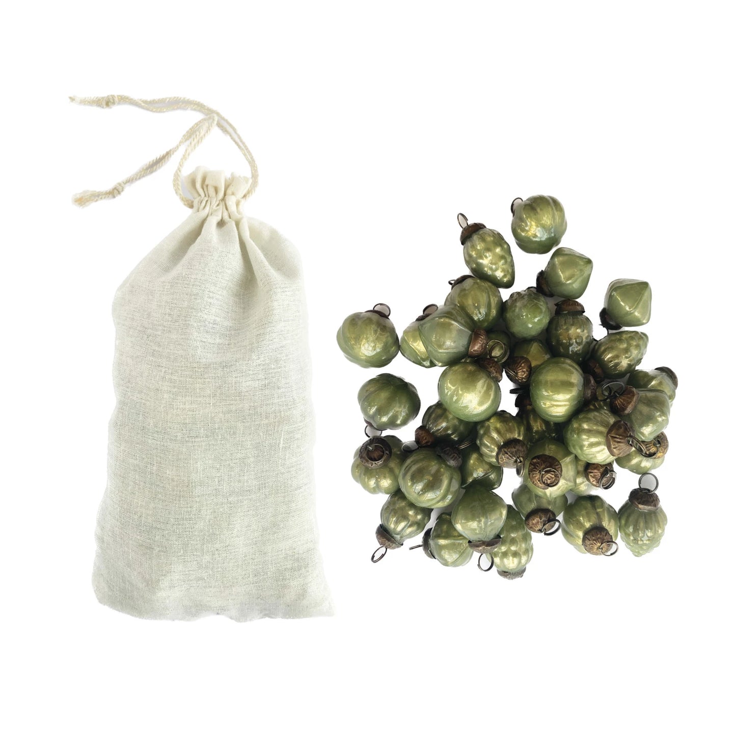 muslin bag filled with ornaments with a pile of green mercury glass ornaments next to it.