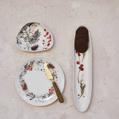 top view of a table with 3 assorted botanical dishes on it, the tray has crackers on it.