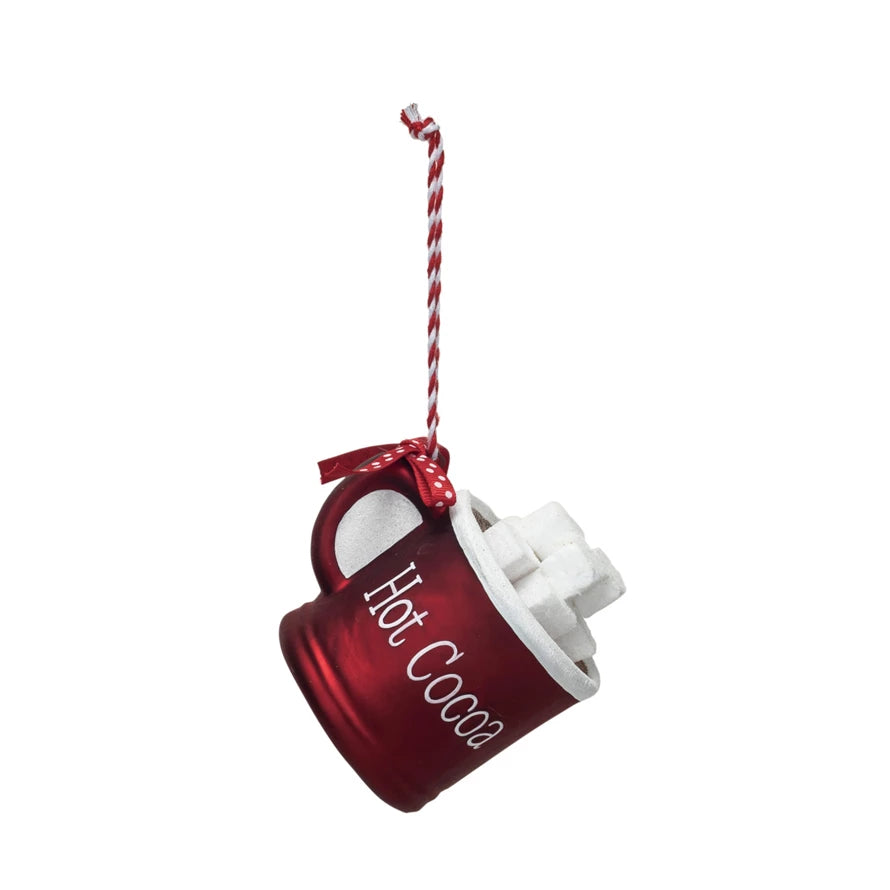 red glass mug ornament hanging by its red and white ribbon hanger.