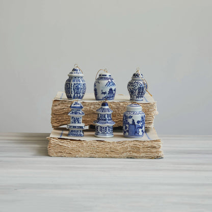 Six assorted ceramic Ginger Jar ornaments arranged on stacks of books.