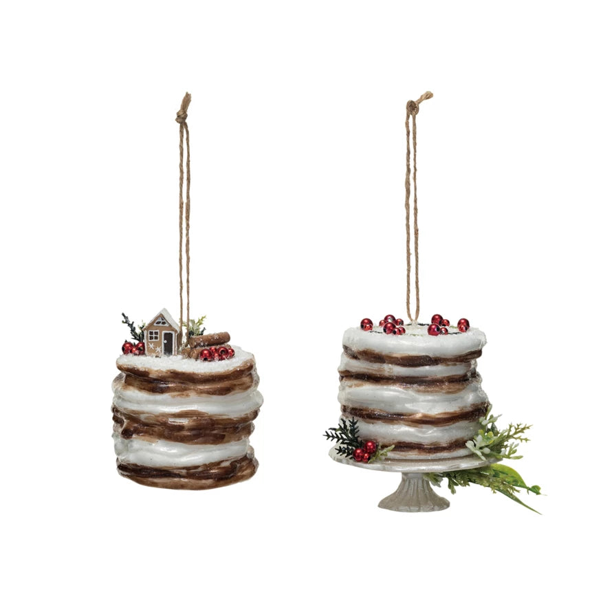 2 styles of glass cake ornaments, one with a house scene on top, the other set on a pedestal.