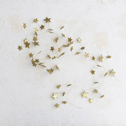 gold star glitter garland laying against a textured background
