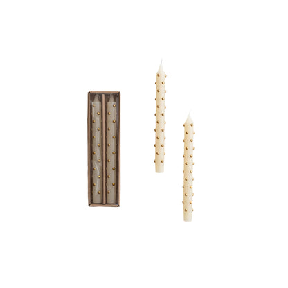 box set of ivory candles with 3d gold dots on them next to 2 candles out of their box on a white background