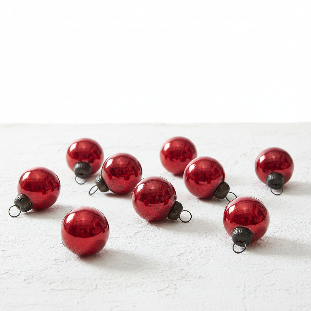 mini red glass ball ornaments scattered on a plaster surface