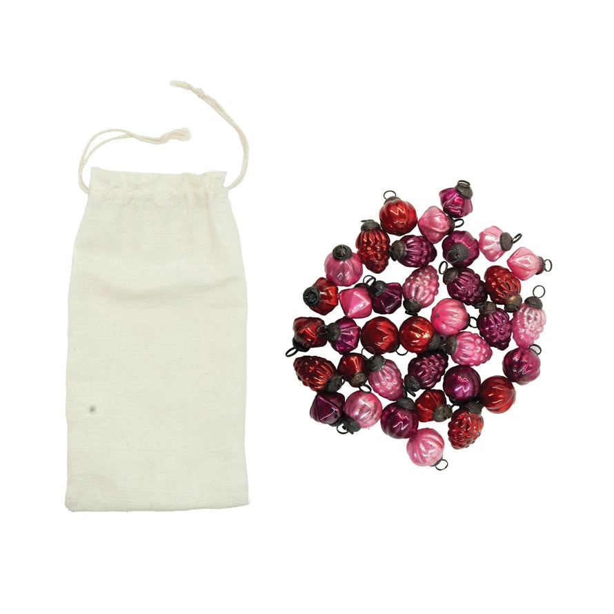 Pink & Red Mercury Glass Ornaments arranged next to a muslin bag