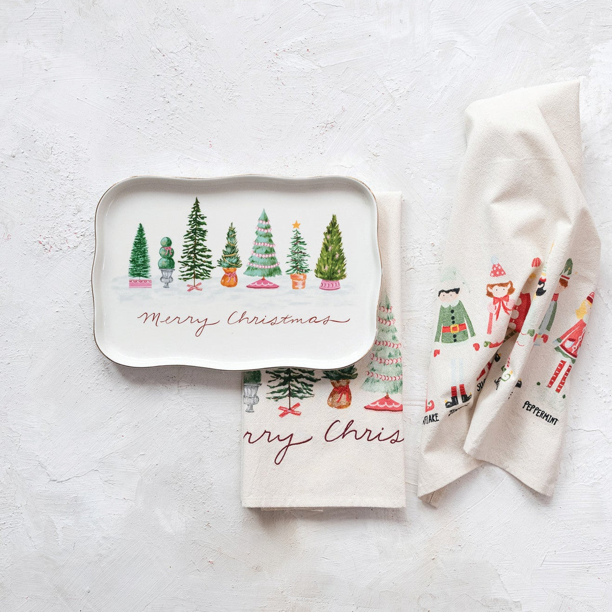 merry christmas platter next to towels on a texture surface