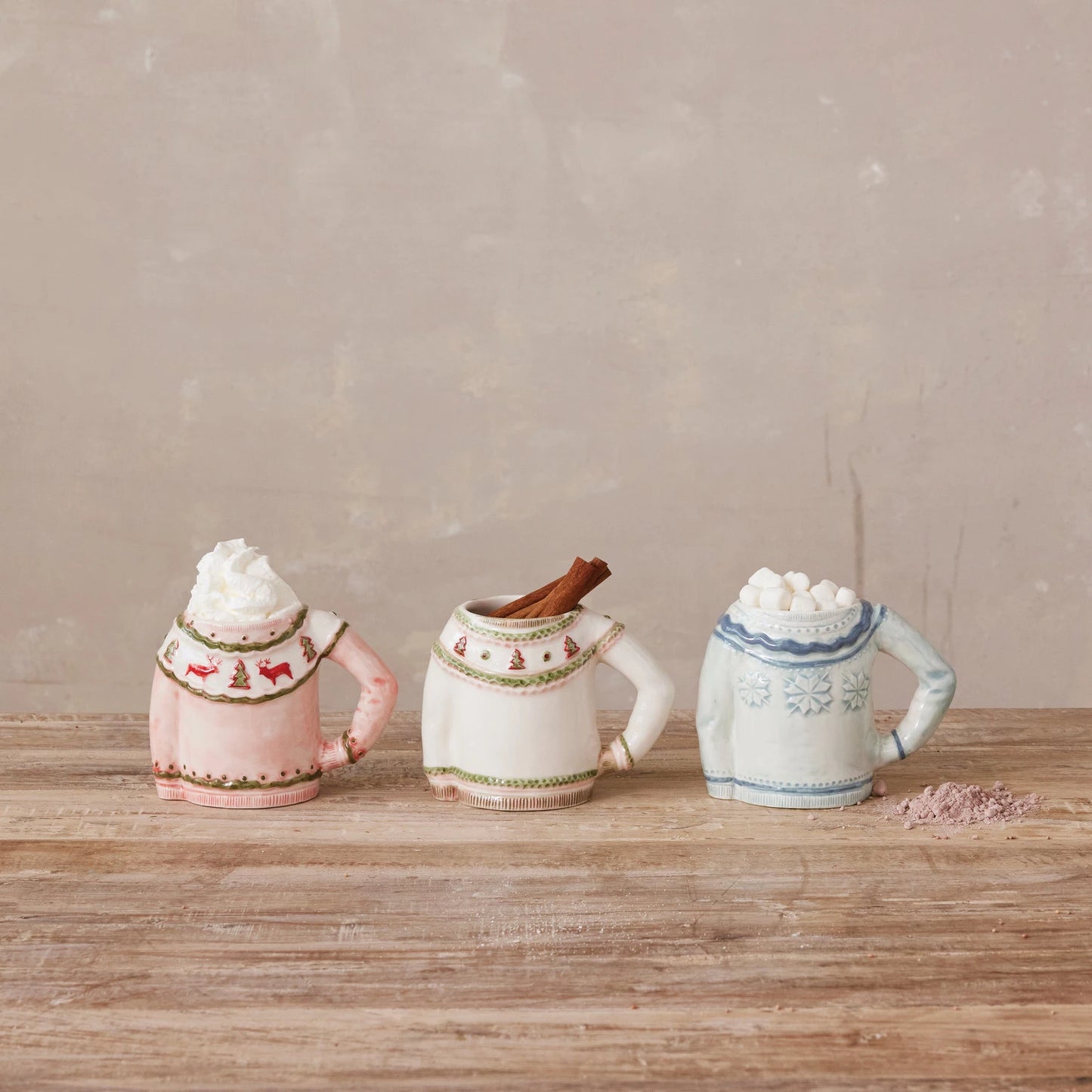Stoneware Sweater Shaped Mugs arranged on a wooden table and filled with hot beverages