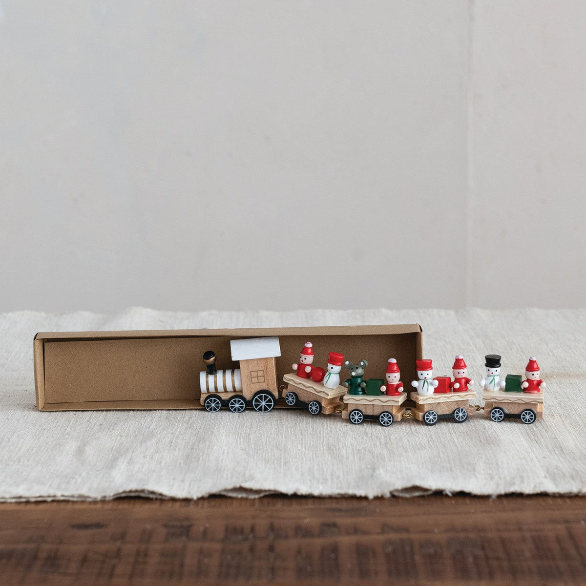 Wooden toy train set with Santa Claus figures, and other passengers shown on a white surface