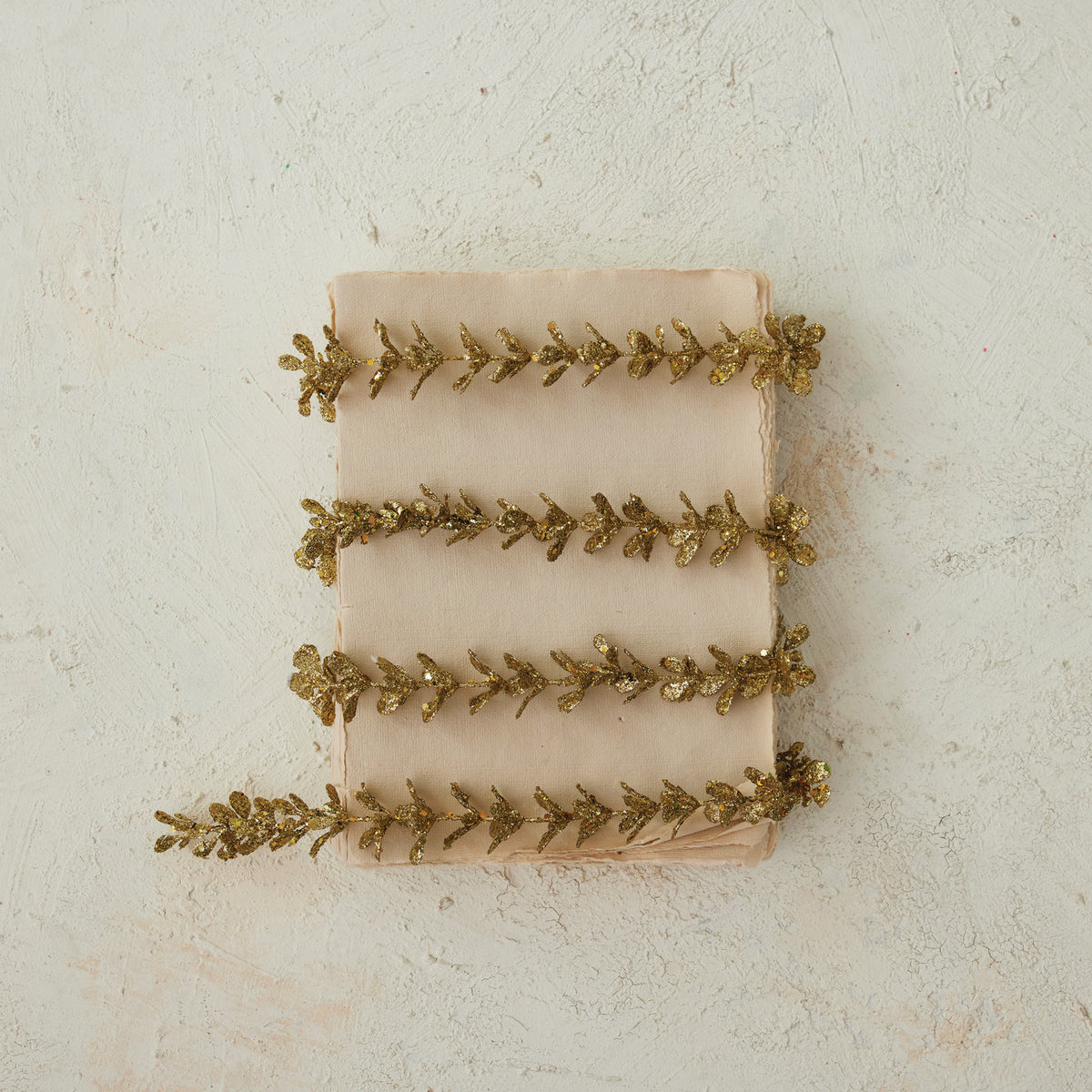 gold box wood garland wrapped around old paper