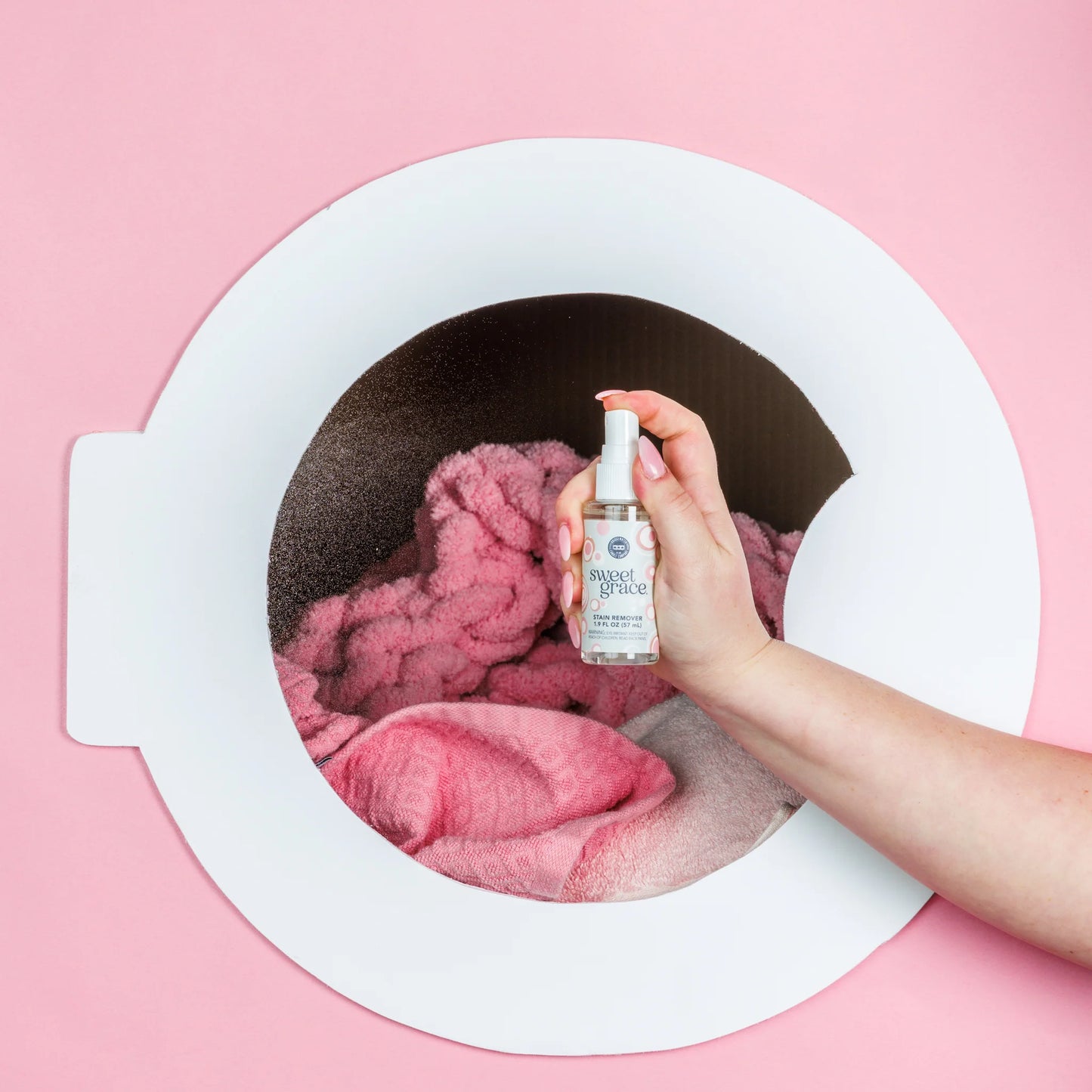 sweet grace stain remover being sprayed on to laundry