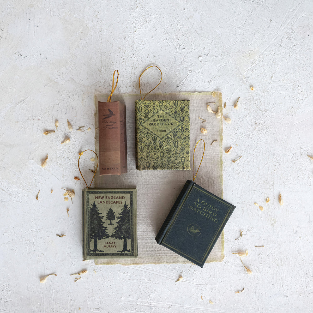 4 book ornaments on a decorated surface