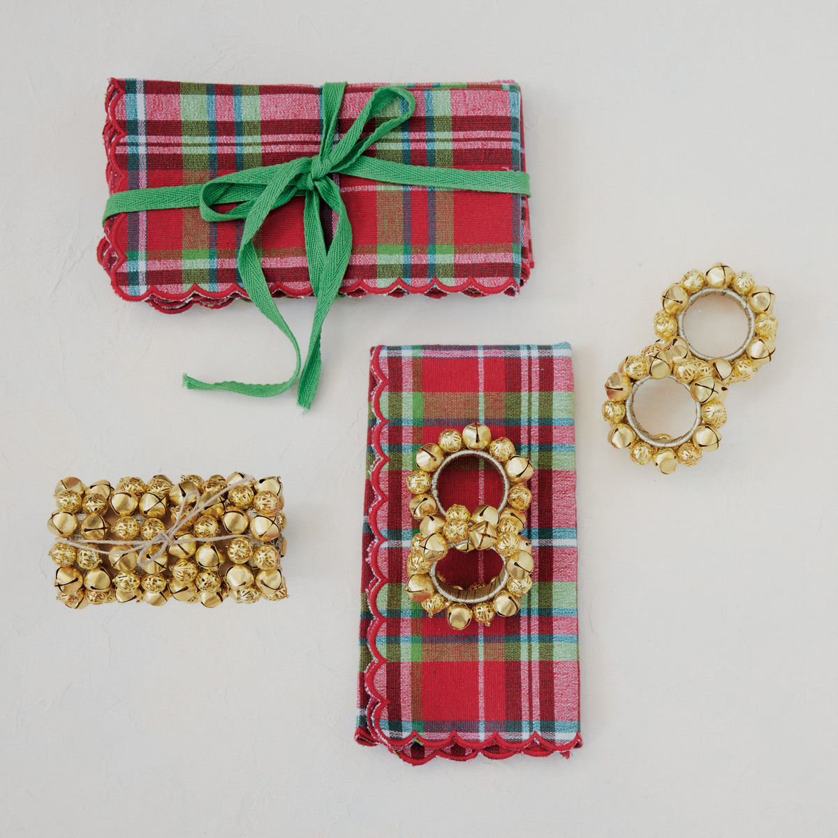 plaid tartan napkins next to gold bell napkin rings