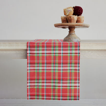 tartan plaid table runner draped over a wooden table with a plate of muffins on it