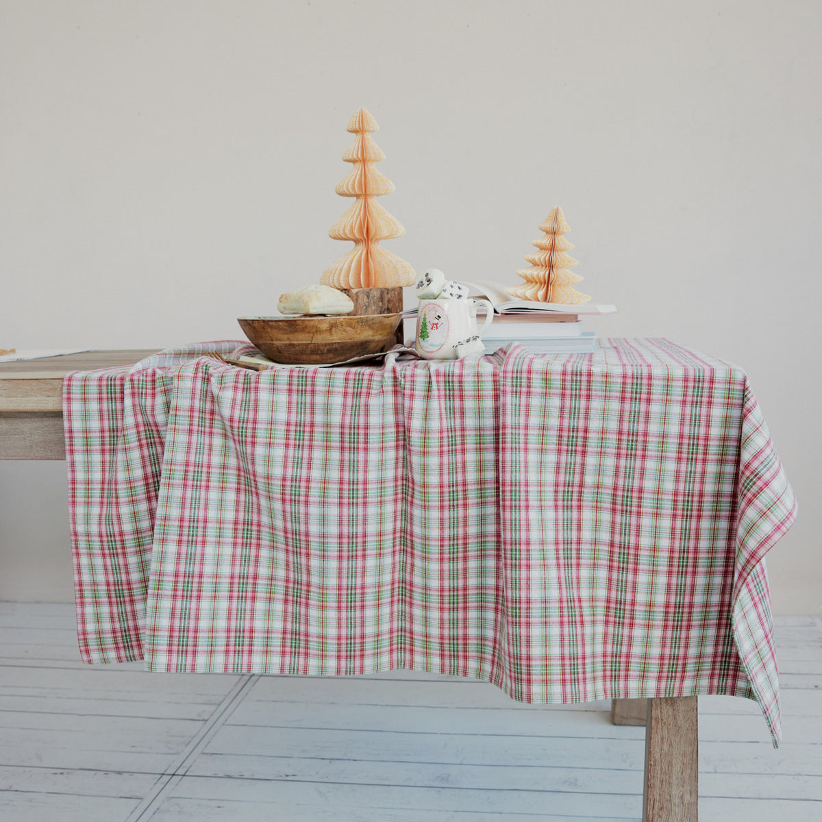plaid table cloth draped on a table with dishes and paper trees set on it