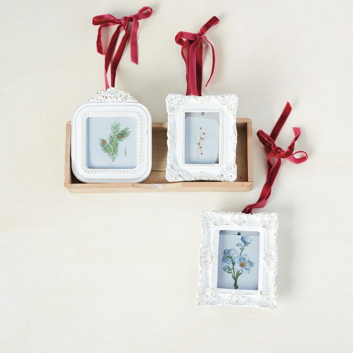 3 photo white frame ornaments in a decorated setting