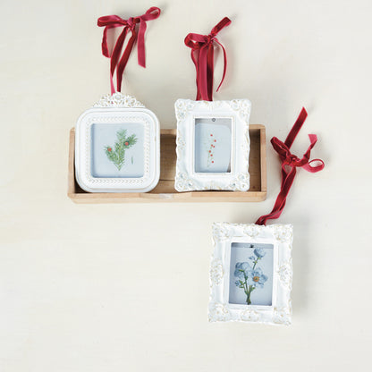 3 photo white frame ornaments in a decorated setting
