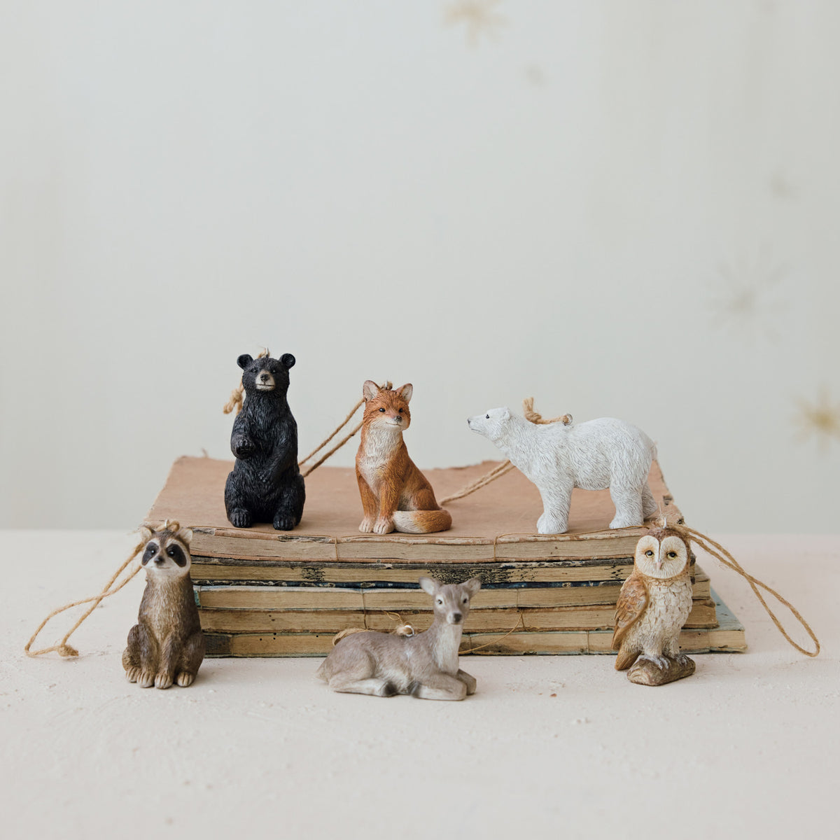 six different animal ornaments arranged on a stack of old books