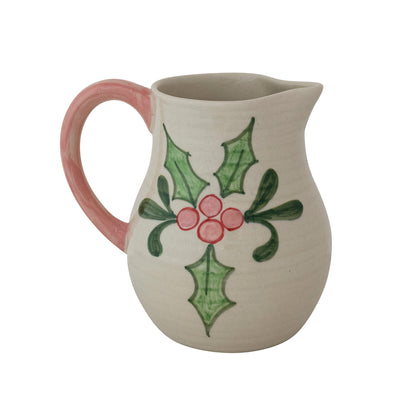 other side of Ceramic pitcher with holly design on a white background